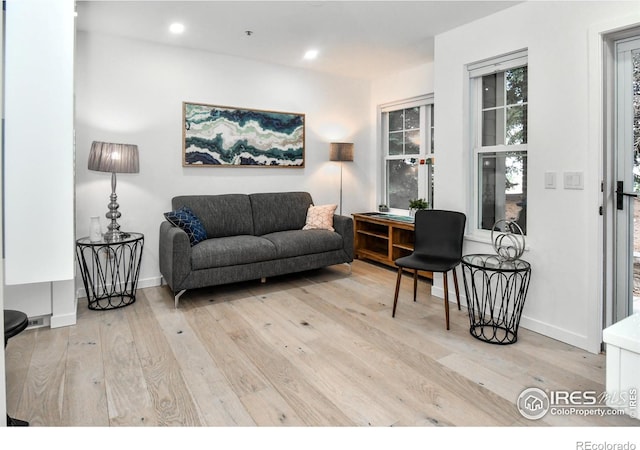 living area featuring wood finished floors, baseboards, and recessed lighting