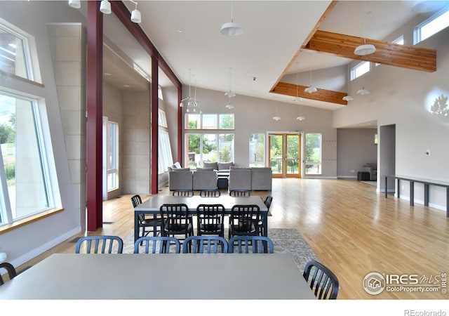 dining space featuring high vaulted ceiling, wood finished floors, baseboards, and beamed ceiling