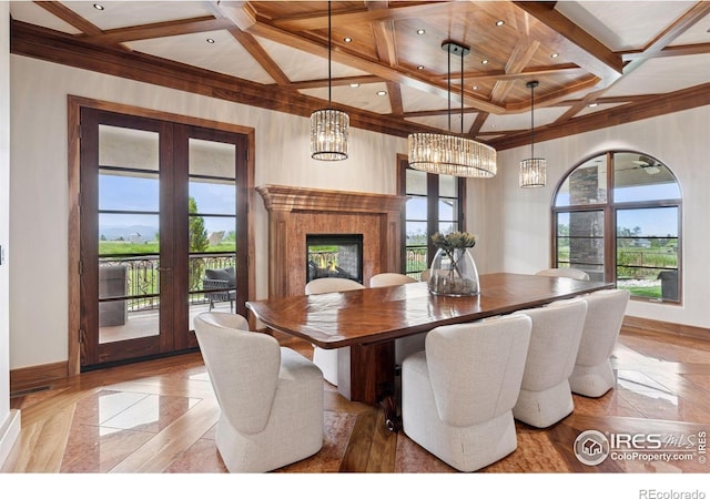 dining space featuring coffered ceiling, a chandelier, baseboards, french doors, and beam ceiling