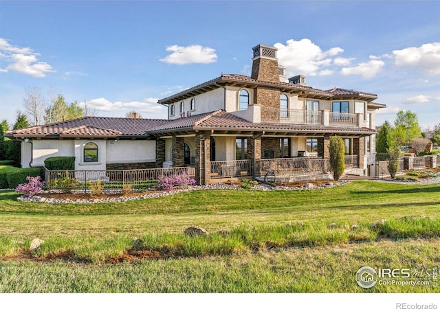 view of front of home featuring stucco siding, a balcony, a chimney, a tiled roof, and stone siding