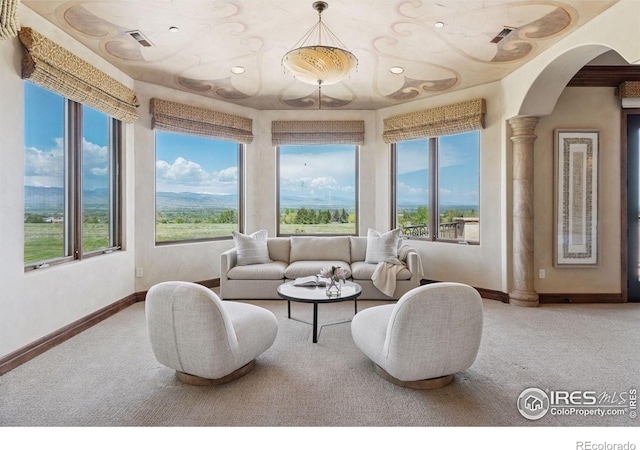 carpeted living area with arched walkways, plenty of natural light, baseboards, and recessed lighting