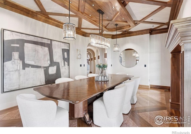 dining space featuring coffered ceiling, baseboards, a chandelier, arched walkways, and beamed ceiling