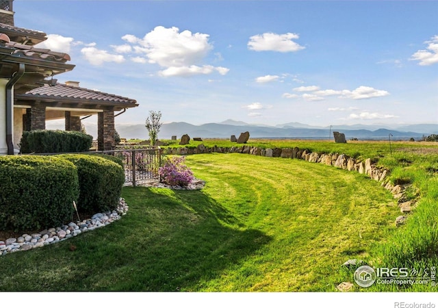 view of green lawn with a mountain view