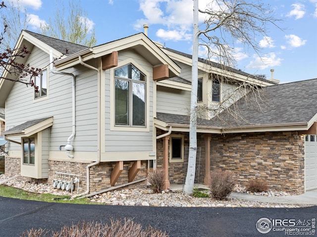 880 Crabapple Ln, Estes Park, CO 80517 - rear view of property featuring stone siding, roof with shingles, and a garage