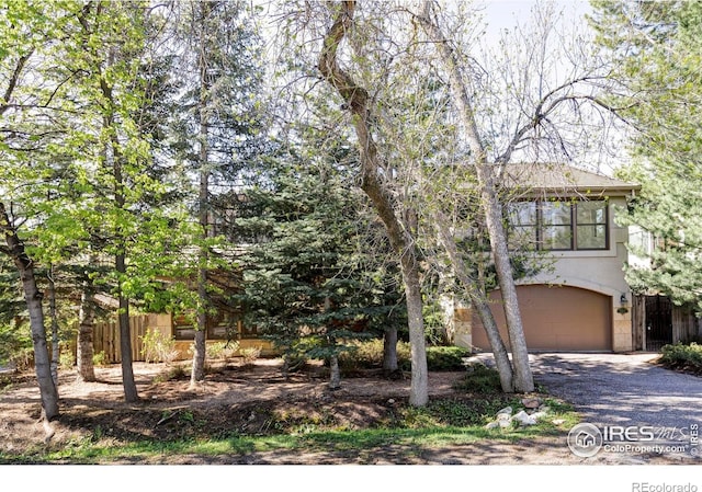 910 Kalmia Ave, Boulder, CO 80304 - view of property hidden behind natural elements with an attached garage, driveway, and fence