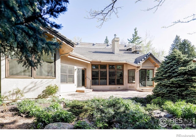 910 Kalmia Ave, Boulder, CO 80304 - back of house with stucco siding, a patio, a chimney, a tiled roof, and entry steps