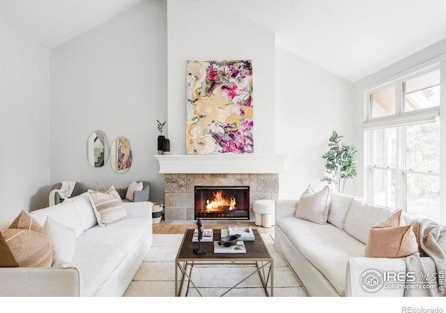 910 Kalmia Ave, Boulder, CO 80304 - living area with lofted ceiling, a tiled fireplace, and wood finished floors