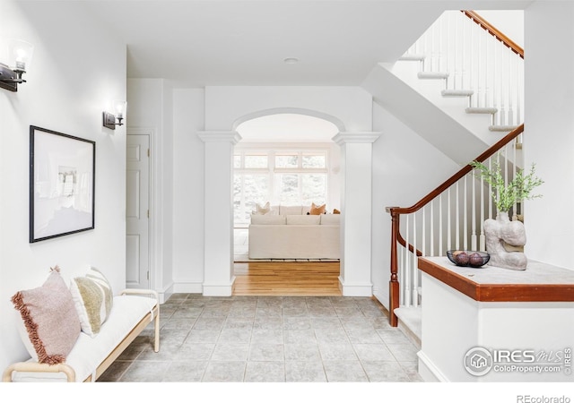 910 Kalmia Ave, Boulder, CO 80304 - hallway featuring stairs, ornate columns, arched walkways, and baseboards