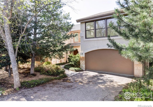 910 Kalmia Ave, Boulder, CO 80304 - view of front facade with an attached garage, stucco siding, and driveway