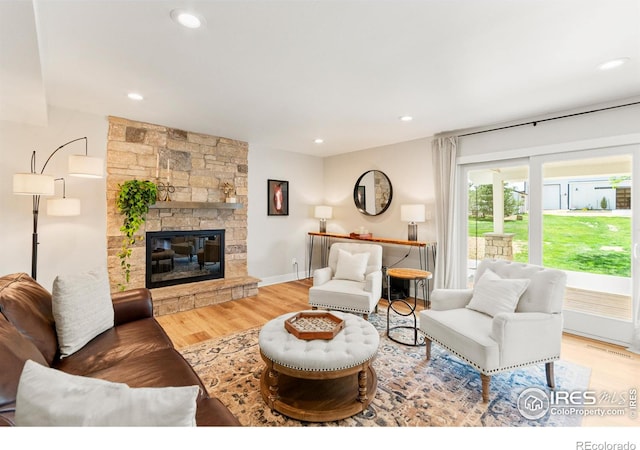 2017 Vaquero St, Longmont, CO 80504 - living area featuring wood finished floors, a stone fireplace, and recessed lighting