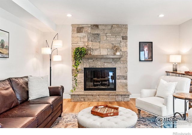 2017 Vaquero St, Longmont, CO 80504 - living area with wood finished floors, baseboards, a stone fireplace, and recessed lighting