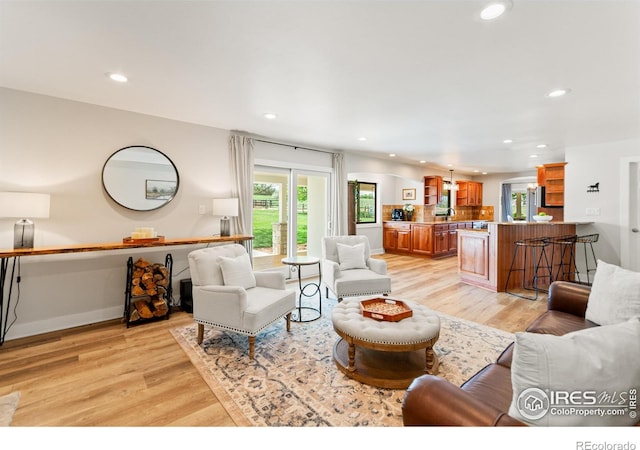 2017 Vaquero St, Longmont, CO 80504 - living room featuring recessed lighting, healthy amount of natural light, light wood-style floors, and baseboards