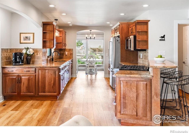 2017 Vaquero St, Longmont, CO 80504 - kitchen with open shelves, arched walkways, stainless steel appliances, a sink, and recessed lighting