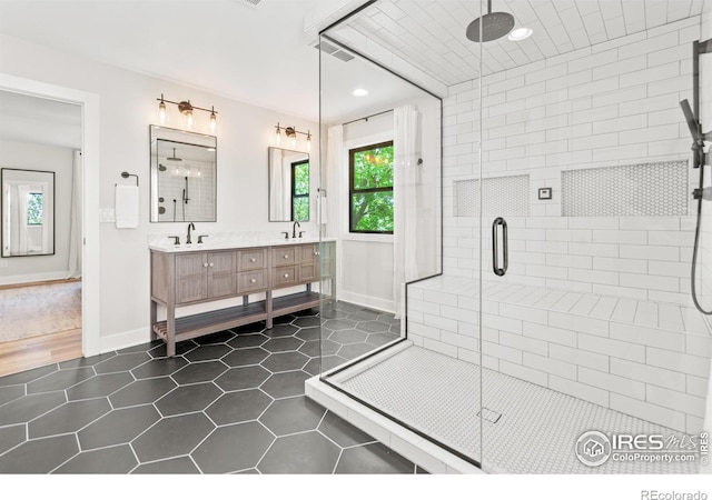 2017 Vaquero St, Longmont, CO 80504 - bathroom featuring tile patterned floors, baseboards, a shower stall, double vanity, and recessed lighting