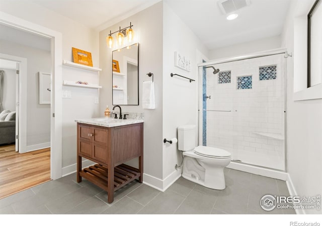 2017 Vaquero St, Longmont, CO 80504 - full bath with baseboards, toilet, a stall shower, vanity, and tile patterned floors