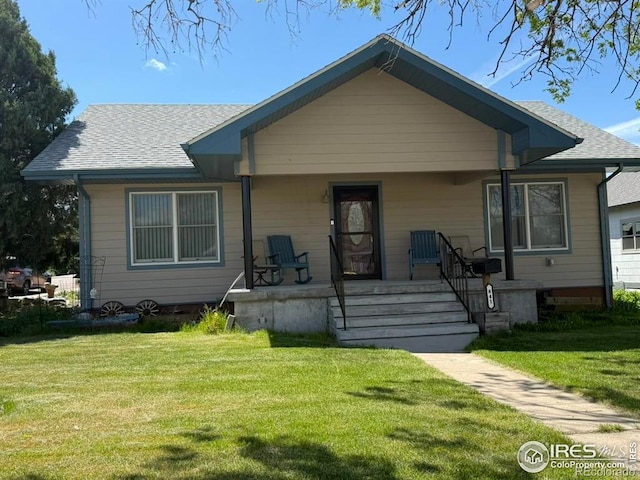 841 Dexter St, Wray, CO 80758 - bungalow-style house featuring covered porch, a front lawn, and roof with shingles