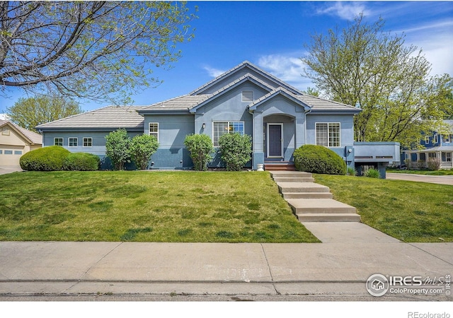 3742 Florentine Cir, Longmont, CO 80503 - view of front of house featuring a tile roof, a front lawn, and stucco siding
