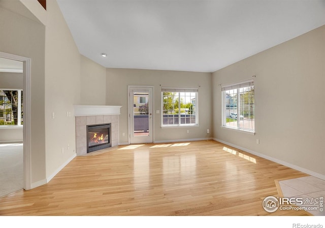 3742 Florentine Cir, Longmont, CO 80503 - unfurnished living room featuring light wood-style flooring, a tile fireplace, baseboards, and recessed lighting