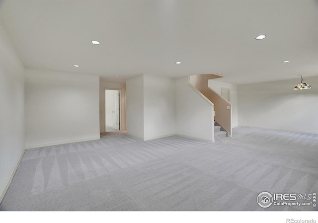3742 Florentine Cir, Longmont, CO 80503 - unfurnished living room with light carpet, recessed lighting, baseboards, and stairway