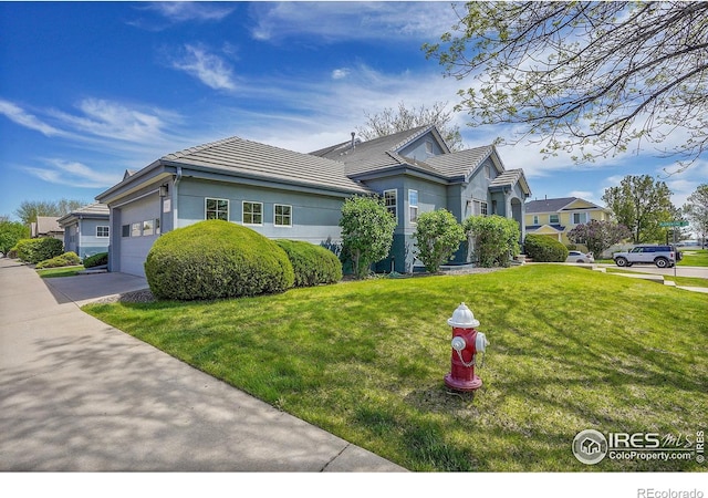 3742 Florentine Cir, Longmont, CO 80503 - view of front of property with a front lawn, a garage, stucco siding, and a tiled roof