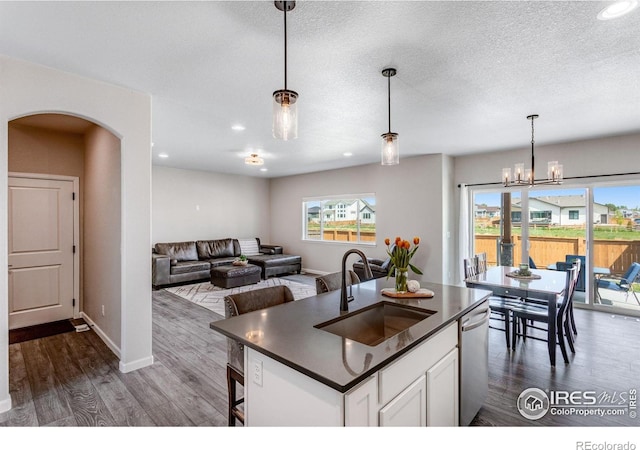 kitchen featuring a sink, dark countertops, plenty of natural light, dark wood finished floors, and recessed lighting