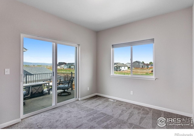 unfurnished room with carpet flooring and baseboards