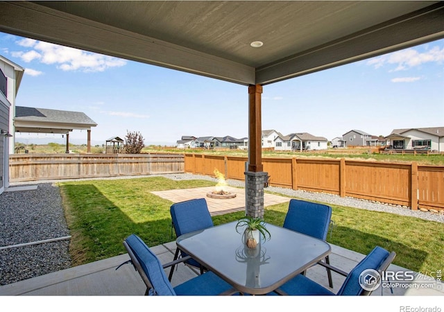 view of patio / terrace with a residential view, outdoor dining area, and a fire pit