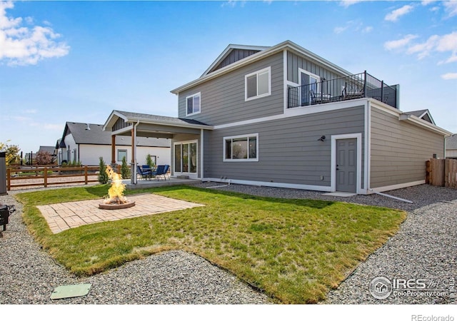 back of house with an outdoor fire pit, board and batten siding, and a patio area