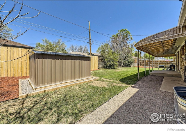 view of yard with a shed, an outdoor structure, and a patio