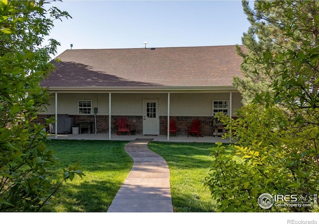 view of front facade featuring a patio area, stucco siding, and a front lawn