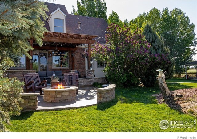 back of property featuring an outdoor fire pit, a pergola, a lawn, and a patio