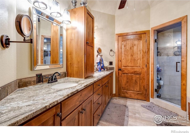 bathroom featuring double vanity, a stall shower, and ceiling fan