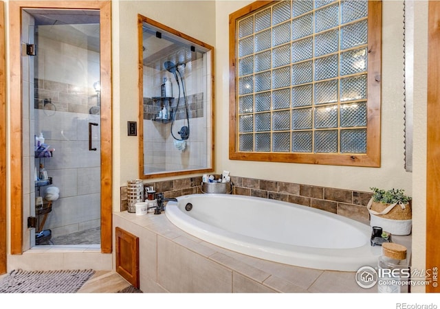 bathroom with a shower stall and a garden tub