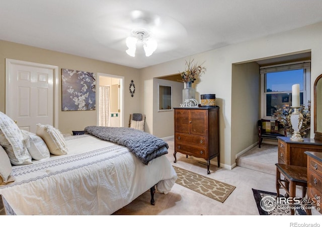 bedroom featuring light colored carpet, baseboards, and connected bathroom