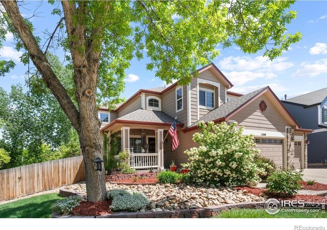 view of front of property with an attached garage, fence, covered porch, concrete driveway, and roof with shingles
