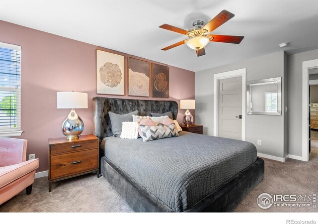 carpeted bedroom featuring baseboards and ceiling fan