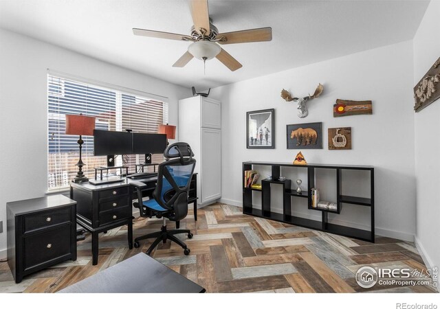 office featuring a ceiling fan and baseboards