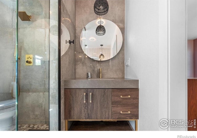 full bath featuring a tile shower and vanity