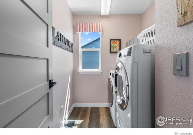 laundry room featuring washer and clothes dryer, dark wood finished floors, and baseboards