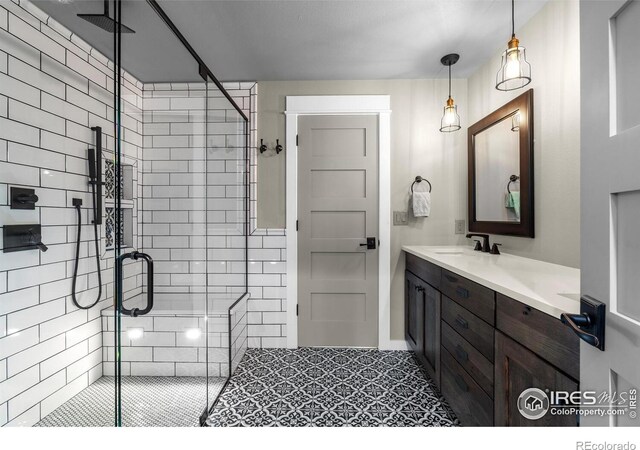 full bath with vanity, a stall shower, and tile patterned floors