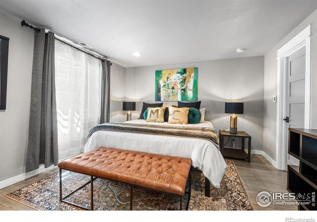 bedroom with baseboards and wood finished floors