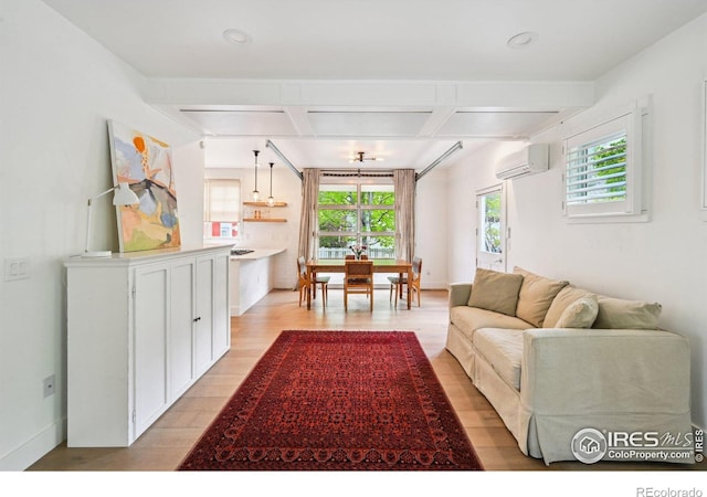 living area with light wood-style flooring, coffered ceiling, an AC wall unit, beamed ceiling, and baseboards