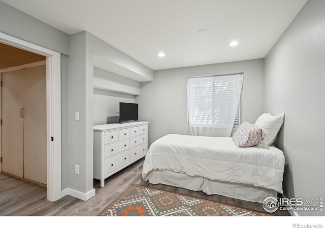 bedroom with wood finished floors, recessed lighting, and baseboards