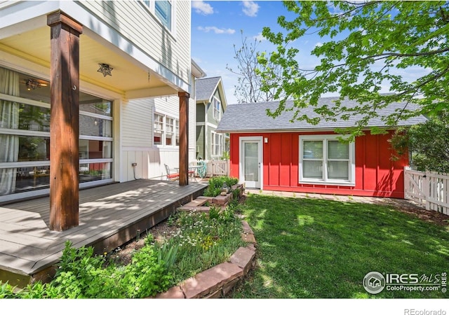 doorway to property featuring board and batten siding, a wooden deck, and roof with shingles