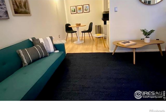 living area with wood finished floors and baseboards