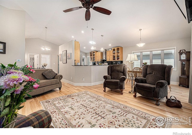 living room featuring lofted ceiling, ceiling fan, light wood-style floors, a chandelier, and baseboards