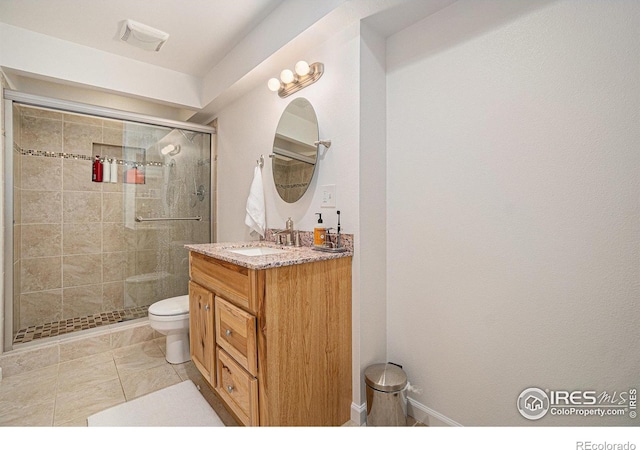bathroom with a shower stall, toilet, and vanity