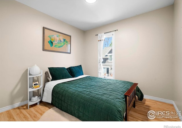 bedroom with baseboards and wood finished floors