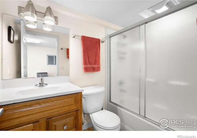 bathroom featuring vanity, toilet, and combined bath / shower with glass door