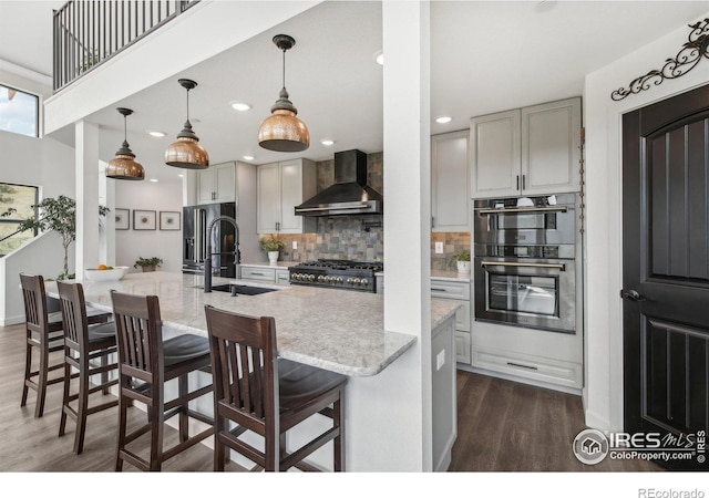 2118 Dry Creek Dr, Lyons, CO 80540 - kitchen with wall chimney range hood, a sink, dark wood finished floors, decorative backsplash, and light stone counters